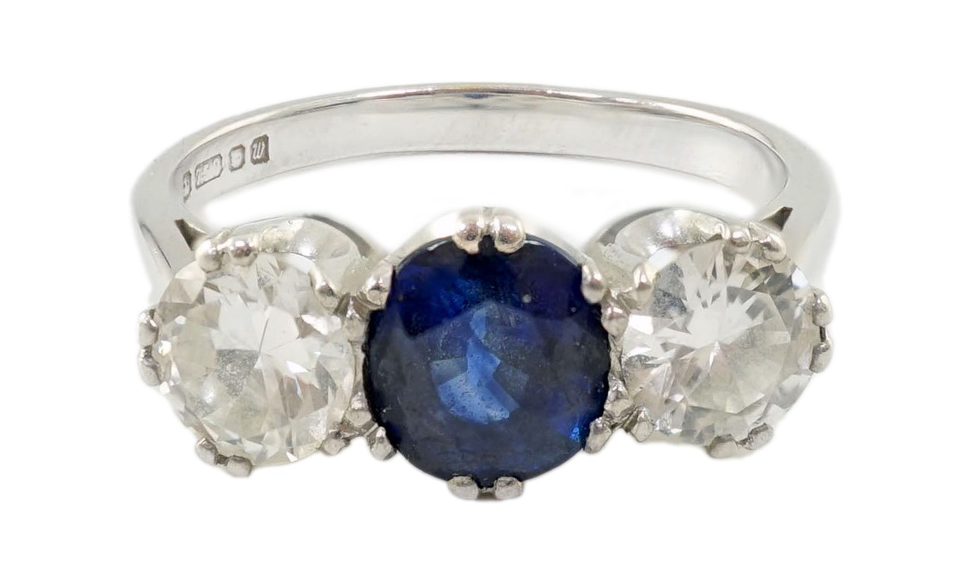 A modern 18ct white gold, single stone oval cut sapphire and two stone round cut diamond set ring